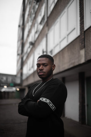 Olivier Okito wearing a BVNE sweater on a London estate.